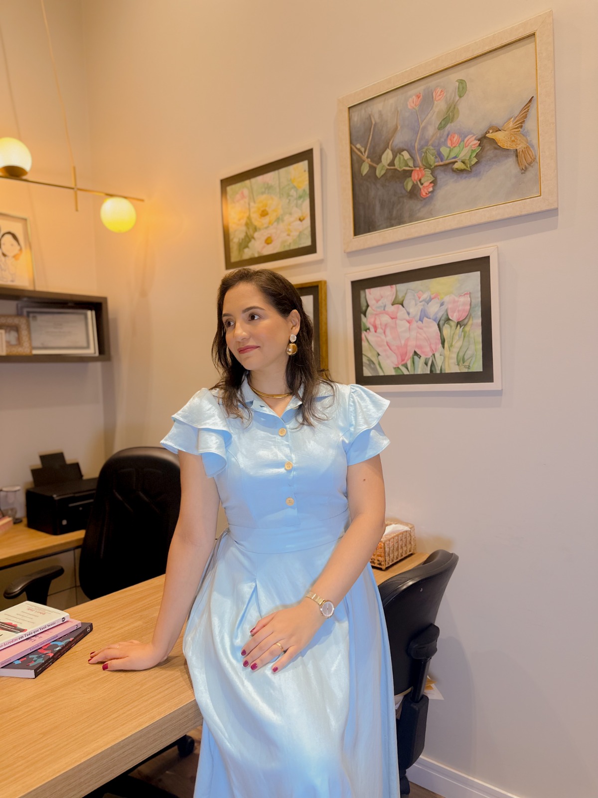 Carla Suzana Marinho in the office wearing a blue dress